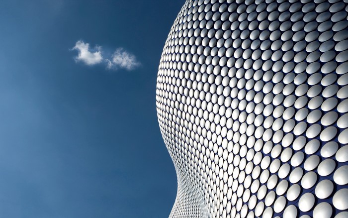 Modern building facade against a blue sky with clouds