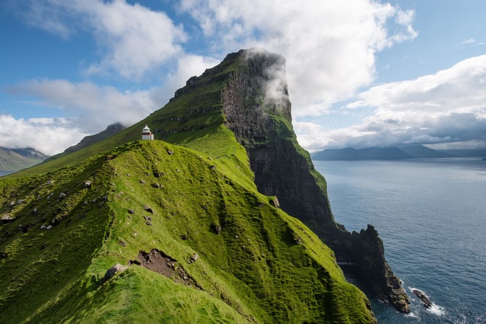 Lighthouse on a grassy cliff overlooking the ocean