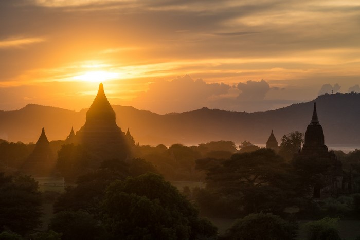 Temples silhouetted against a golden sunset in Bagan, Myanmar