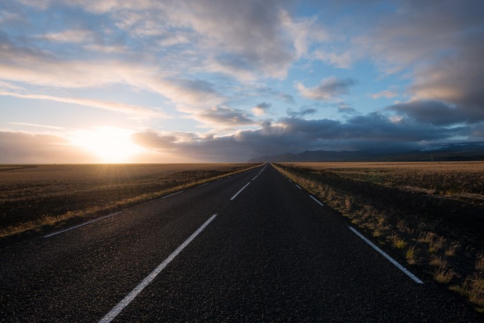 Road through a field at sunset