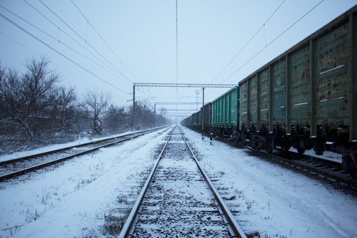 Freight train on snowy railway tracks in winter