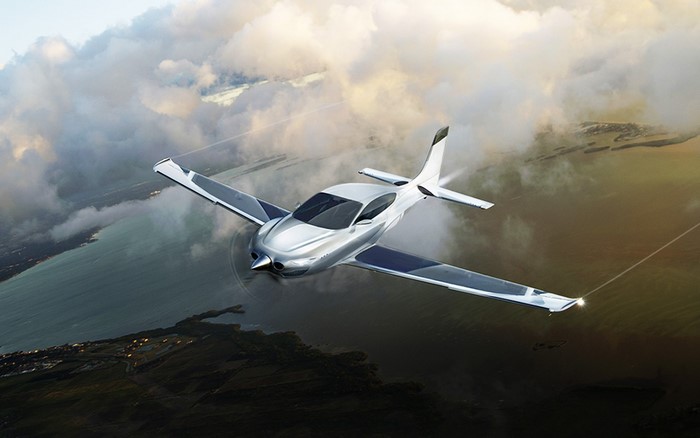 Silver aircraft flying over land and sea