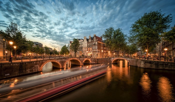Amsterdam canal with bridges and boat long exposure