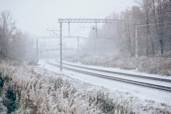 Snowy railway tracks in a misty forest