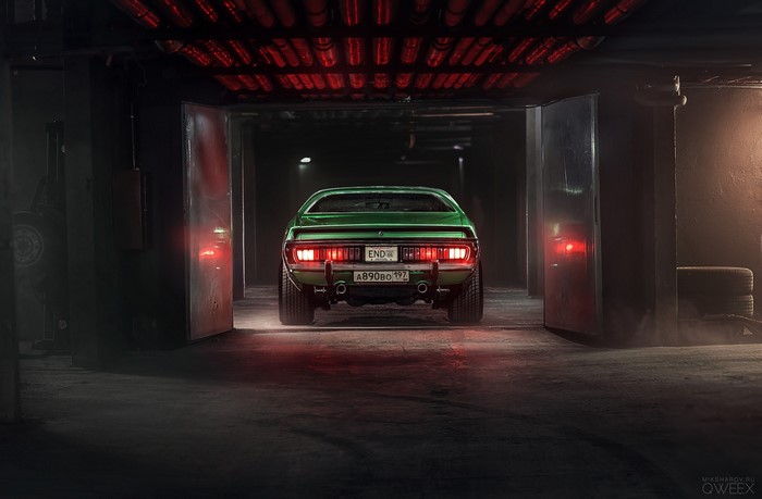 Green Dodge Charger in a dimly lit garage