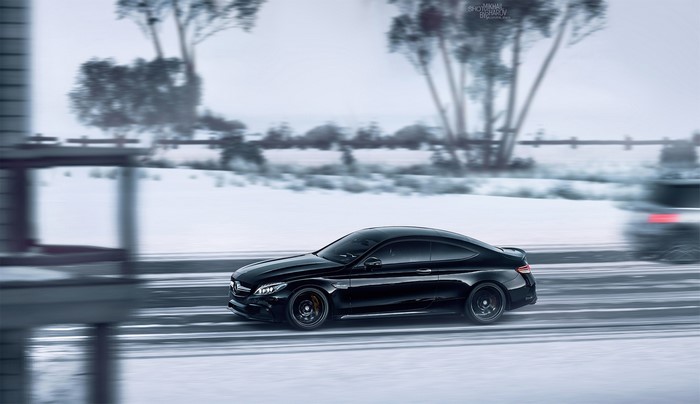 Black Mercedes-Benz Coupe driving on a snowy road