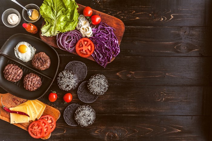 Burger ingredients on a wooden table