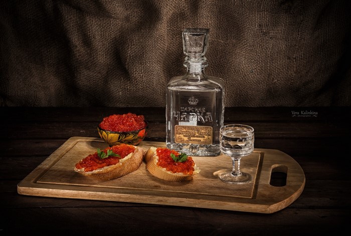 Vodka bottle, shot glass, and caviar on bread