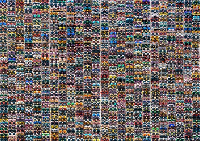 A large collection of colorful sunglasses displayed in a grid.