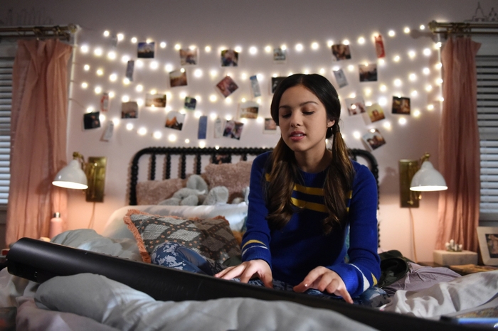 Olivia Rodrigo playing a keyboard in her bedroom