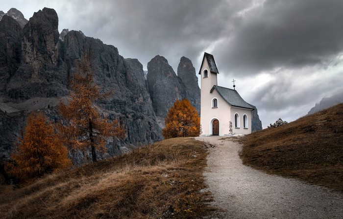 Small church in the Dolomite Alps during fall