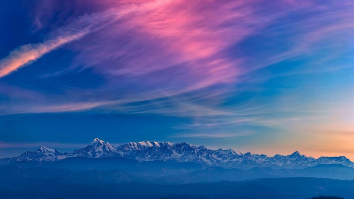 Snowy mountain range under a colorful sky
