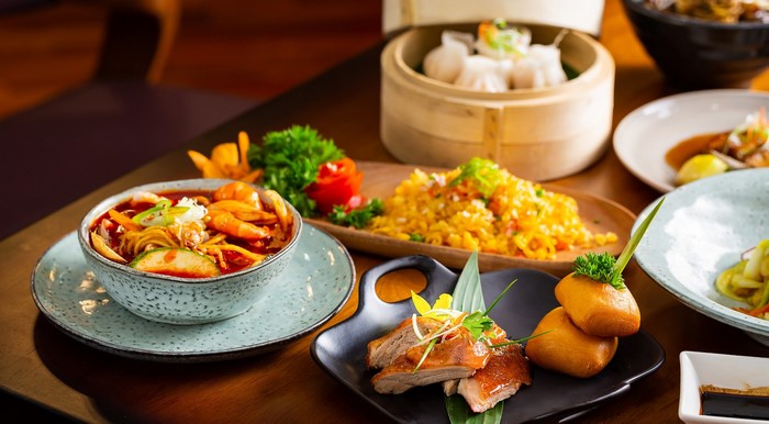 Asian food spread with soup, fried rice, dumplings, and duck