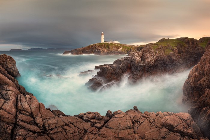 Lighthouse on a rocky coast in Ireland with the Atlantic Ocean