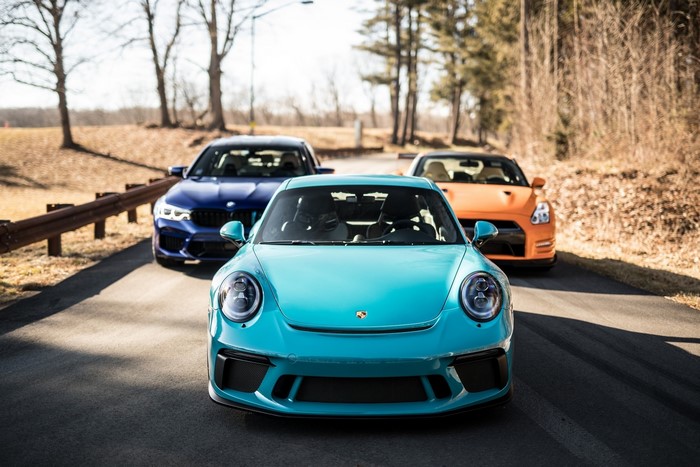 Cyan Porsche 911, Blue BMW M5, and Orange Nissan GT-R on Road