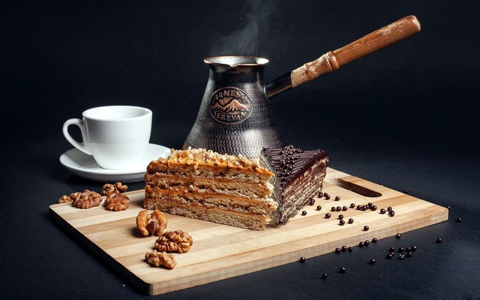 Coffee and cake with walnuts on a cutting board