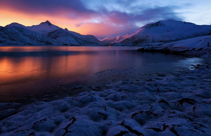 Snowy mountains and lake at sunset in Lofoten, Norway