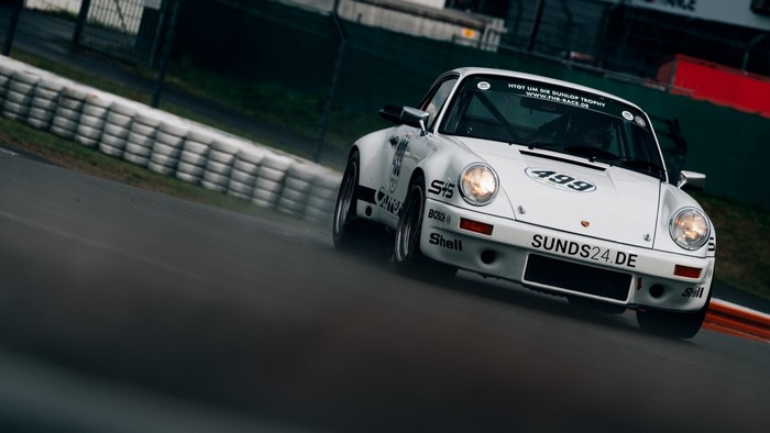 White Porsche 911 race car on a track