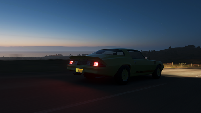 Yellow car driving on a road at dusk in Forza Horizon 4