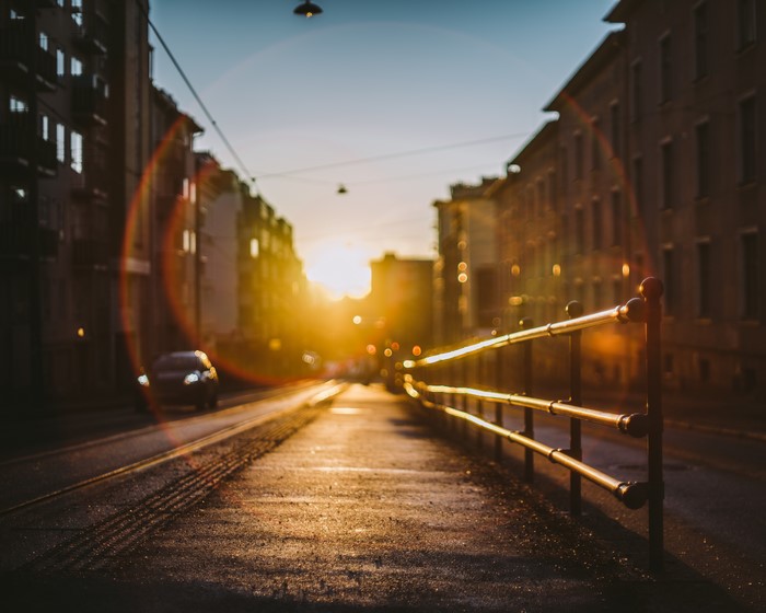 Sunset over a city street with a railing
