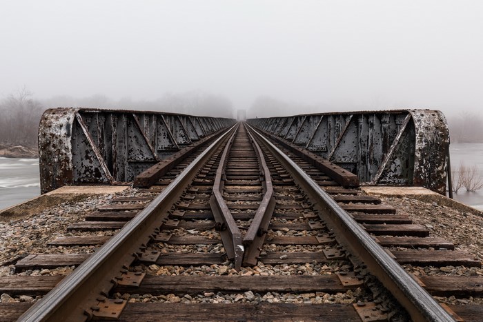 Railroad tracks on a bridge in fog
