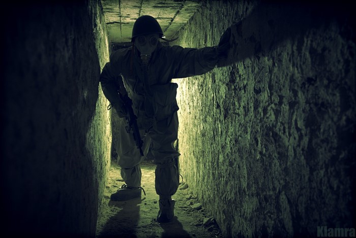 Soldier in gas mask and uniform in abandoned bunker
