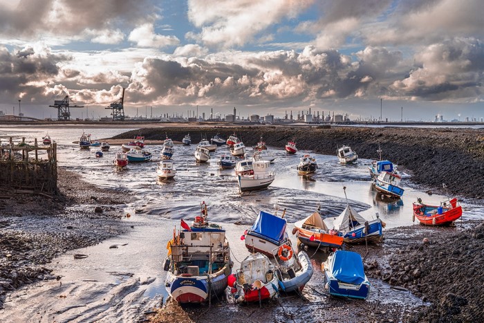 Boats at low tide with industrial background
