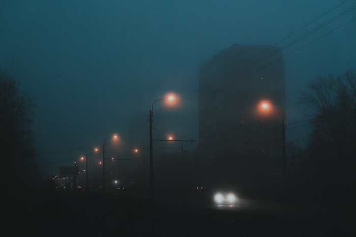 Street lights and a building in the mist at night