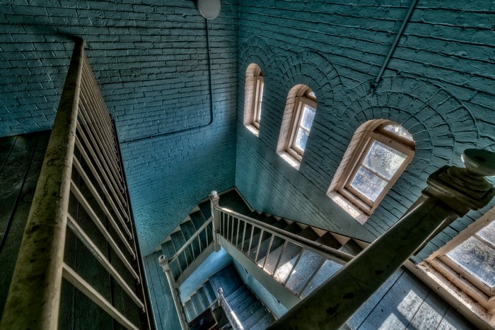 Interior of a building with blue brick walls and a spiral staircase