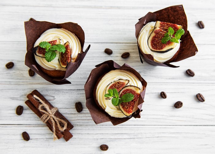 Cupcakes with frosting, figs, and mint leaves