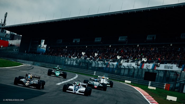 Formula 1 race cars on track with grandstand