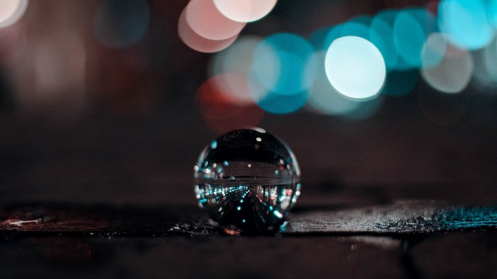 Glass ball reflecting city lights at night