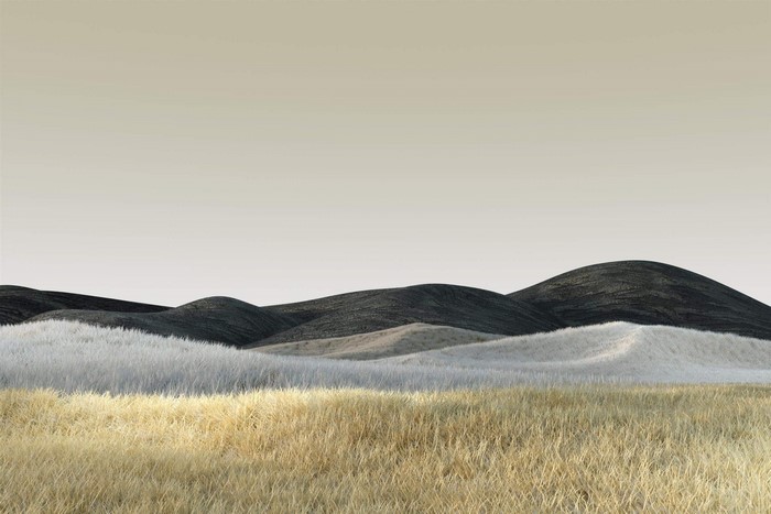Rolling hills with dry grass and dark peaks