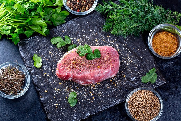 Raw meat steak with spices and herbs