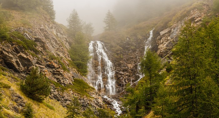 Waterfall in a misty mountain landscape with trees