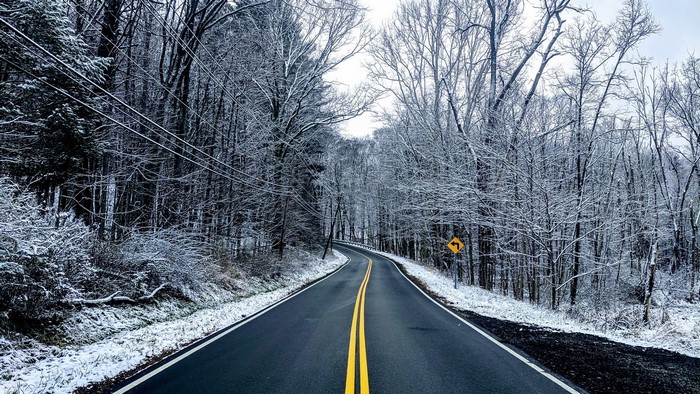 Winding road through a snow-covered forest