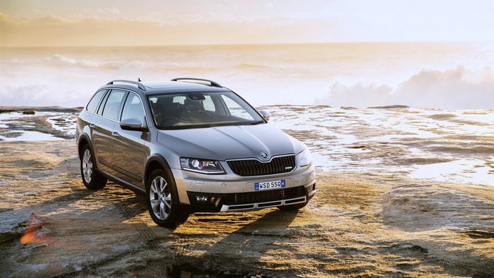 Silver Skoda Octavia Scout parked on rocky shore by the ocean