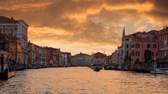 Venice canal with buildings and gondolas at sunset