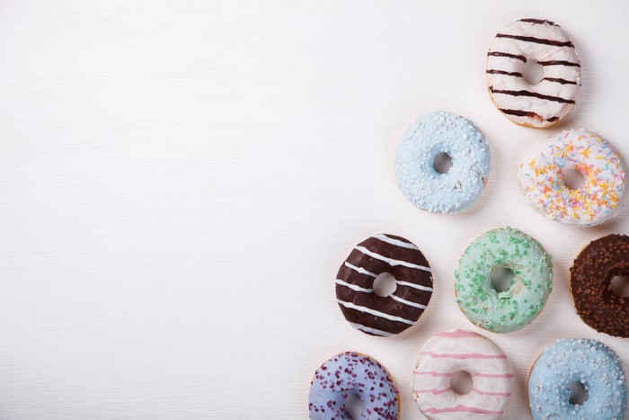 Assortment of colorful donuts on a white wooden table