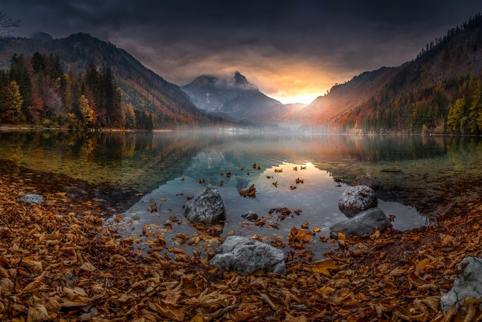 Autumn lake with mountains and fallen leaves