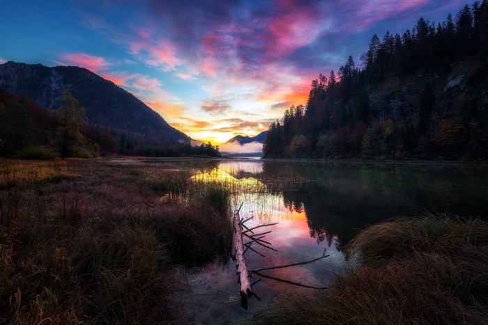 Colorful sunset over a lake with mountains and trees