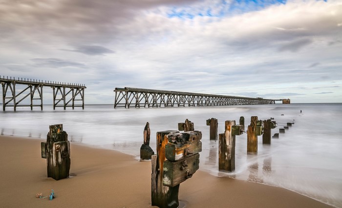 Ruined wooden pier on a beach in England