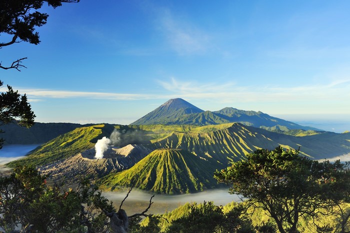 Volcanic landscape with smoking crater and mountains
