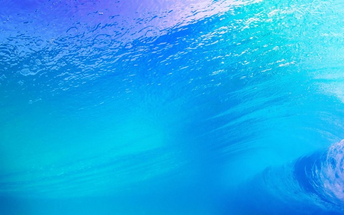 Underwater view of a blue wave with light filtering from above