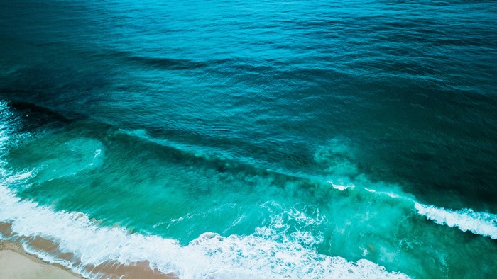 Turquoise ocean waves crashing on a sandy beach