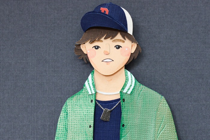 Paper cutout of a young person wearing a baseball cap and jacket