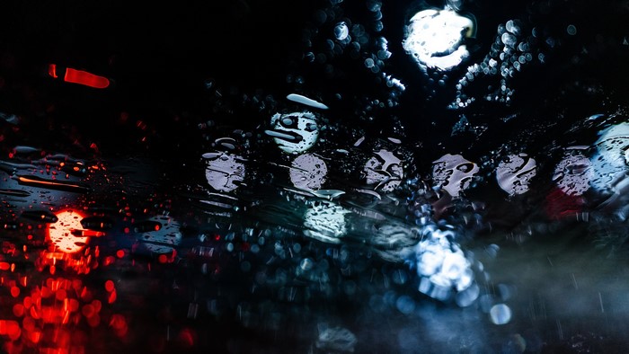 Raindrops on glass with red and blue lights