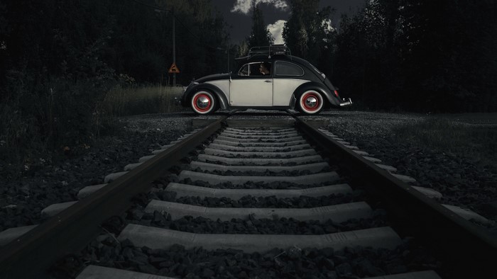 Volkswagen Beetle on railroad tracks at dusk