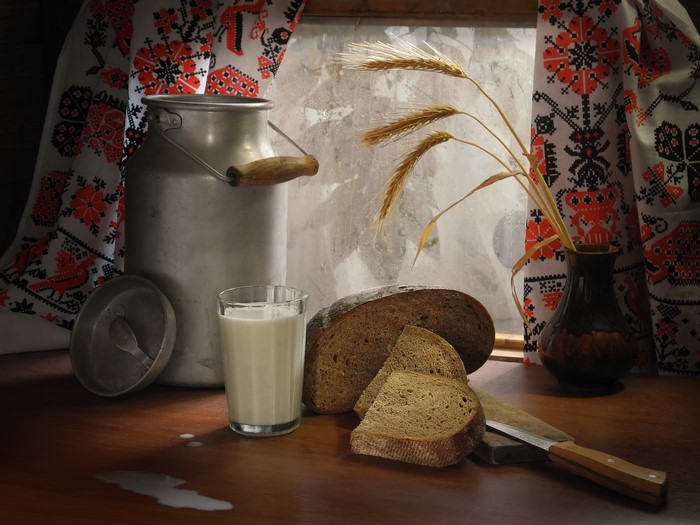 Still life with milk, bread, wheat, and knife