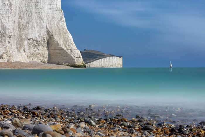 White cliffs and a sailboat on the sea